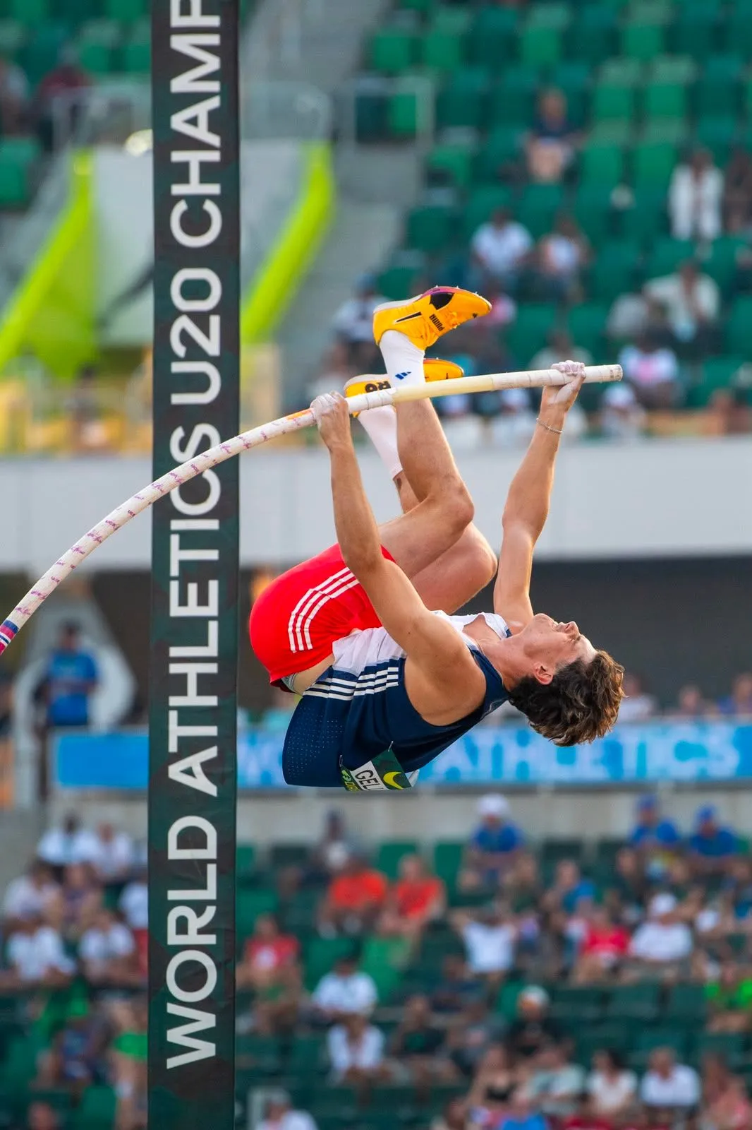 Aloïs Gellens, maillot de l'équipe de France, s'enroule autour de sa perche en plein saut aux Championnats du monde U20 d'Eugene