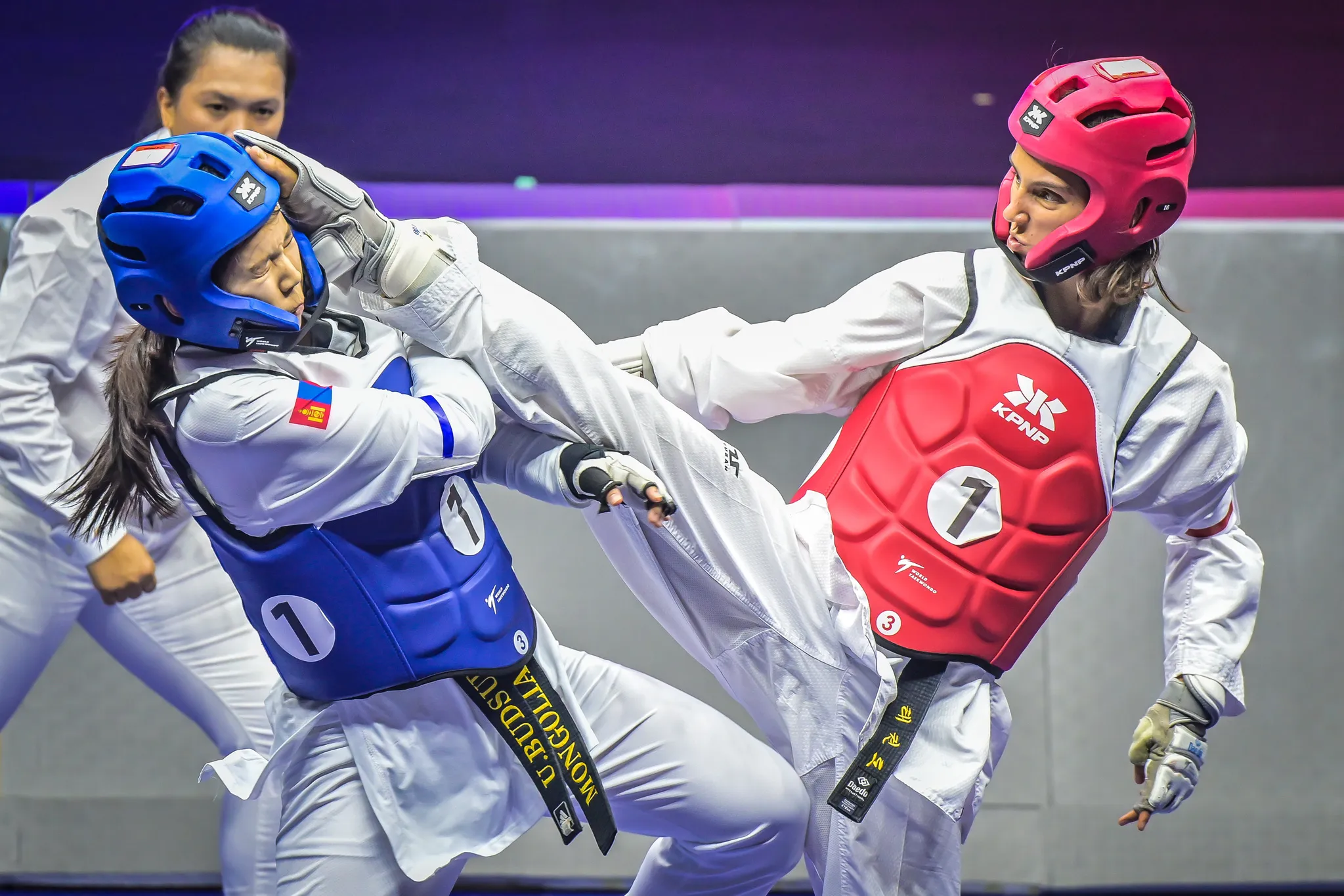 Estelle Causse, casque rouge, porte un coup de pied lors d'un combat de taekwondo