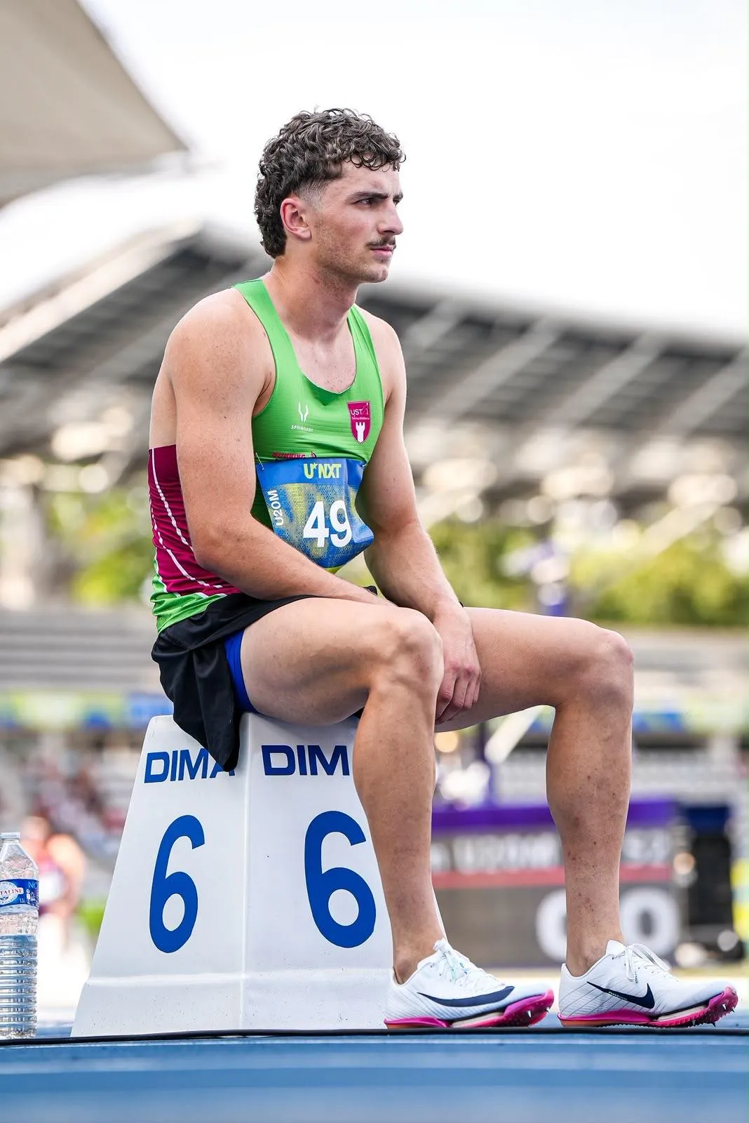 Lucas Couderc, concentré, assis sur le plot de son couloir avant la course